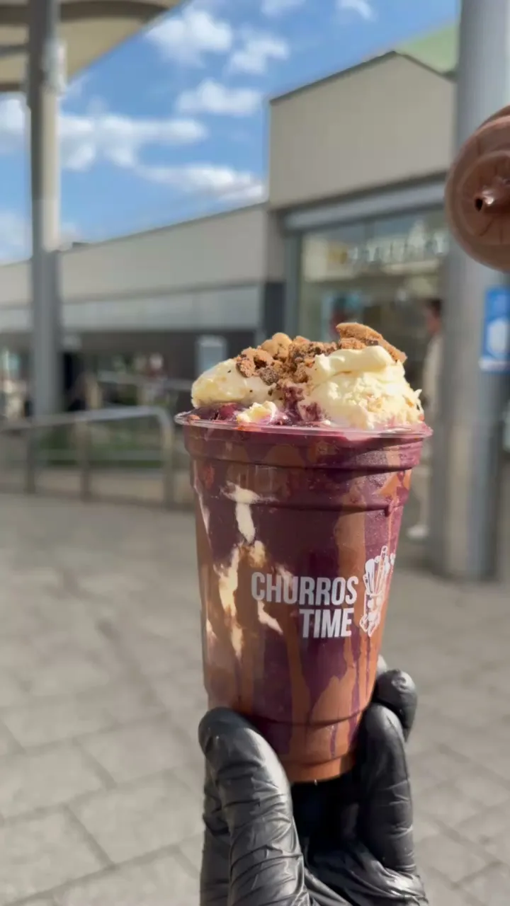 Sauce wird auf eine Açaí Bowl von Churros Time gegossen